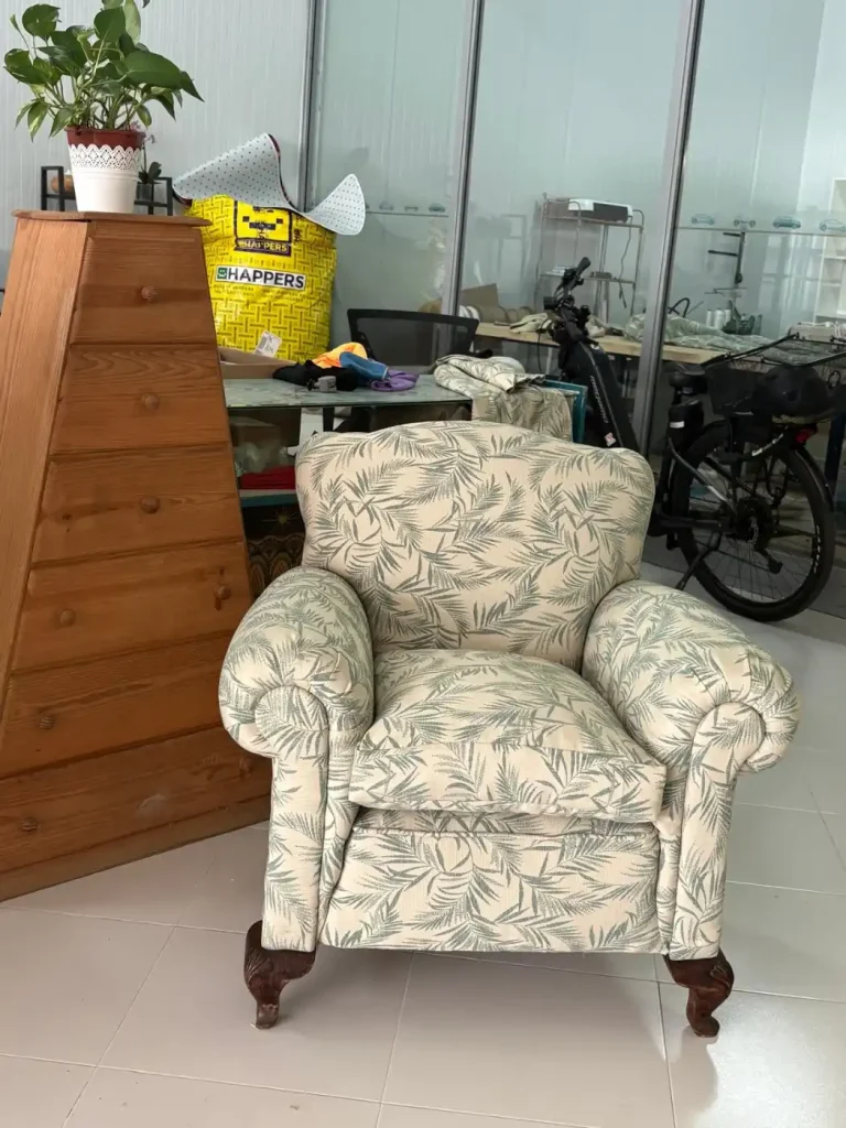 Sillón tapizado con estampado de hojas verdes